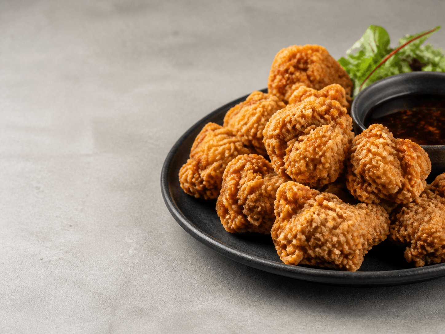 Chicken karaage on a black plate